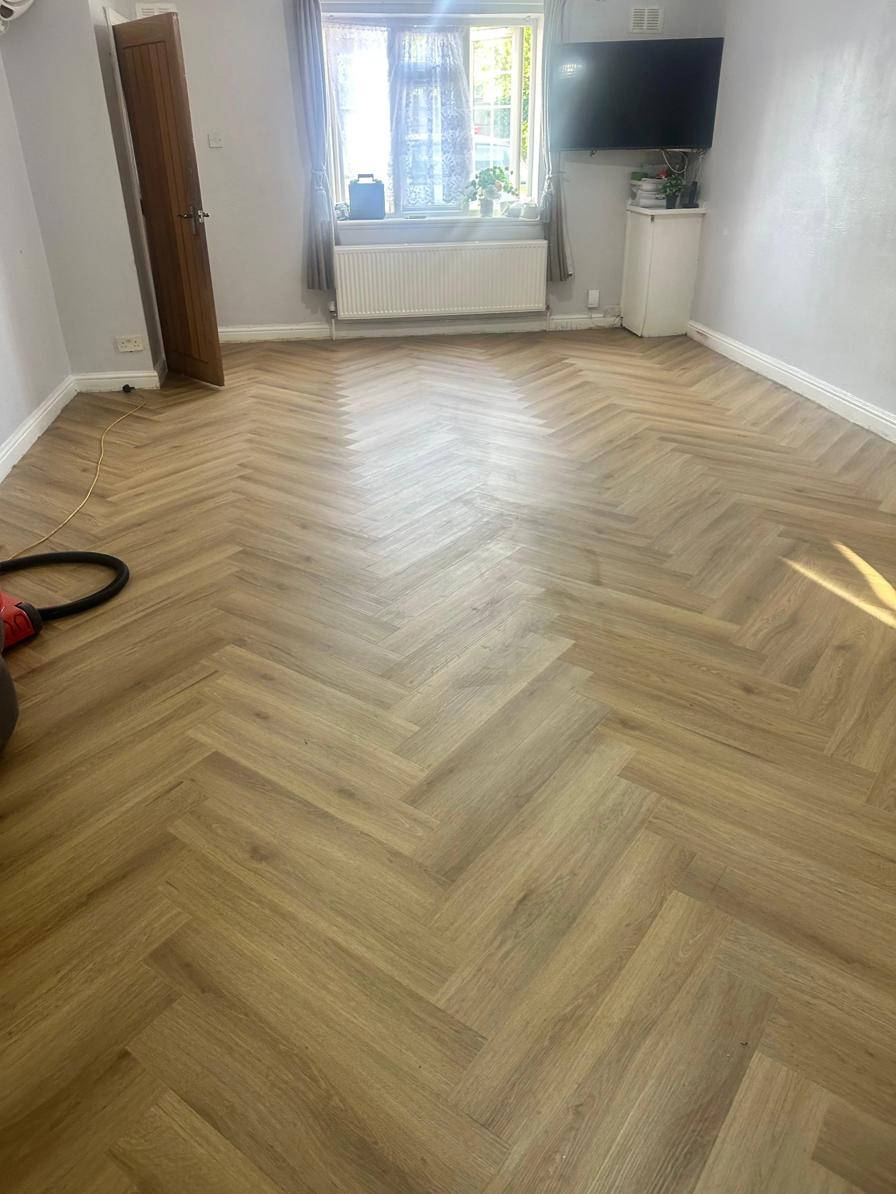 Natural oak herringbone LVT flooring fitted across a living room