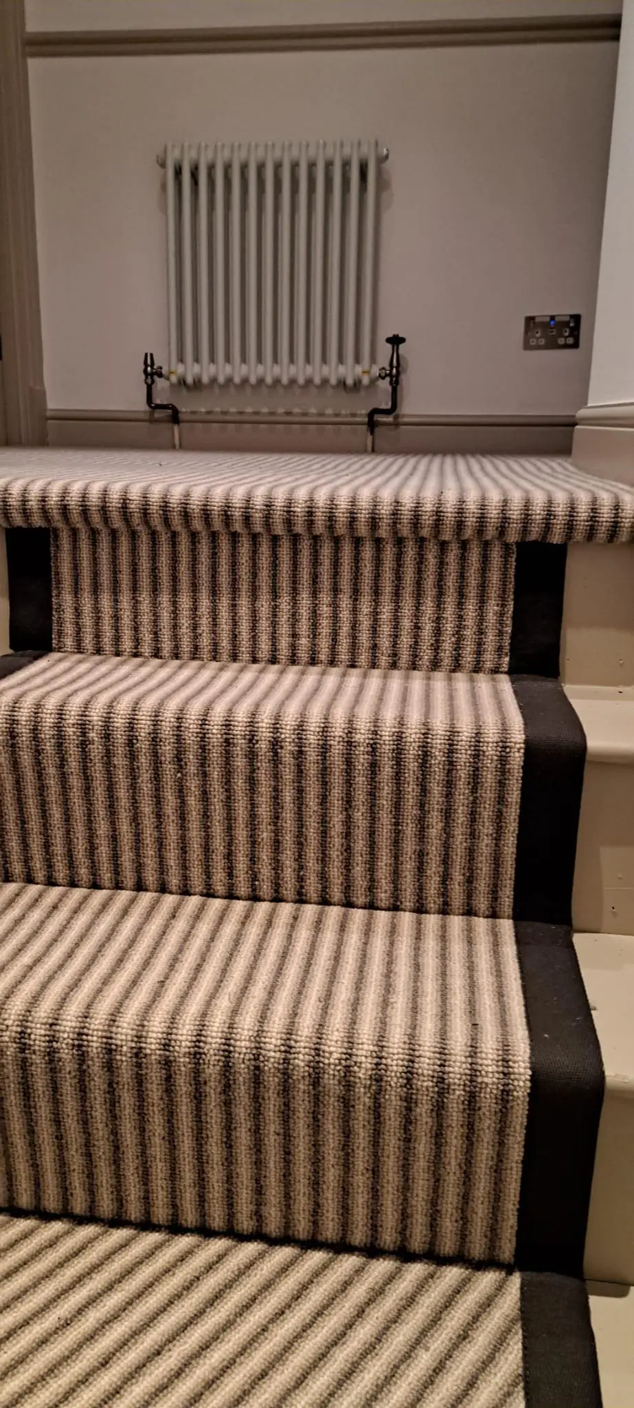 Black and cream striped stair runner with column radiator